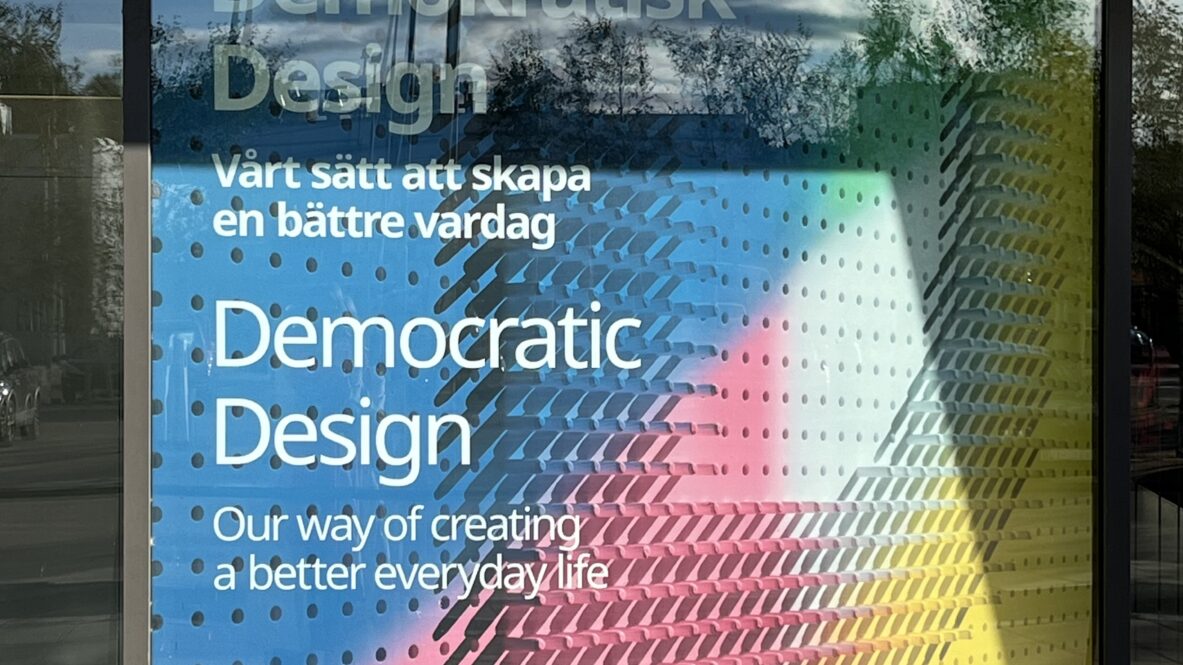 Fönster med färgglad affisch från IKEA Museum. Texten lyder: 'Demokratisk design – vårt sätt att skapa en bättre vardag. Democratic Design – our way of creating a better everyday life'