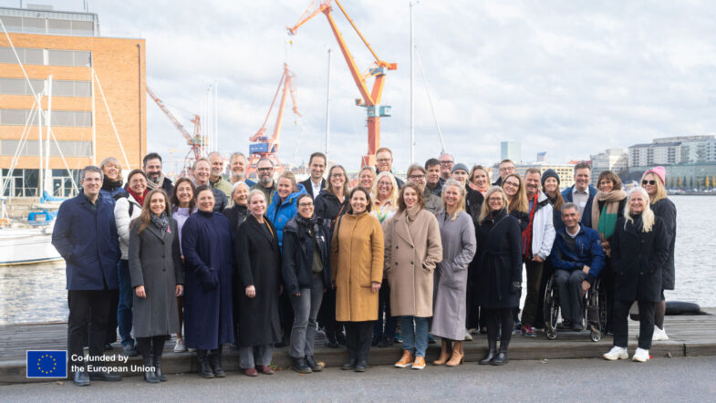 Ca 30 kvinnor och män som fotografers utomhus i ett gruppfoto.