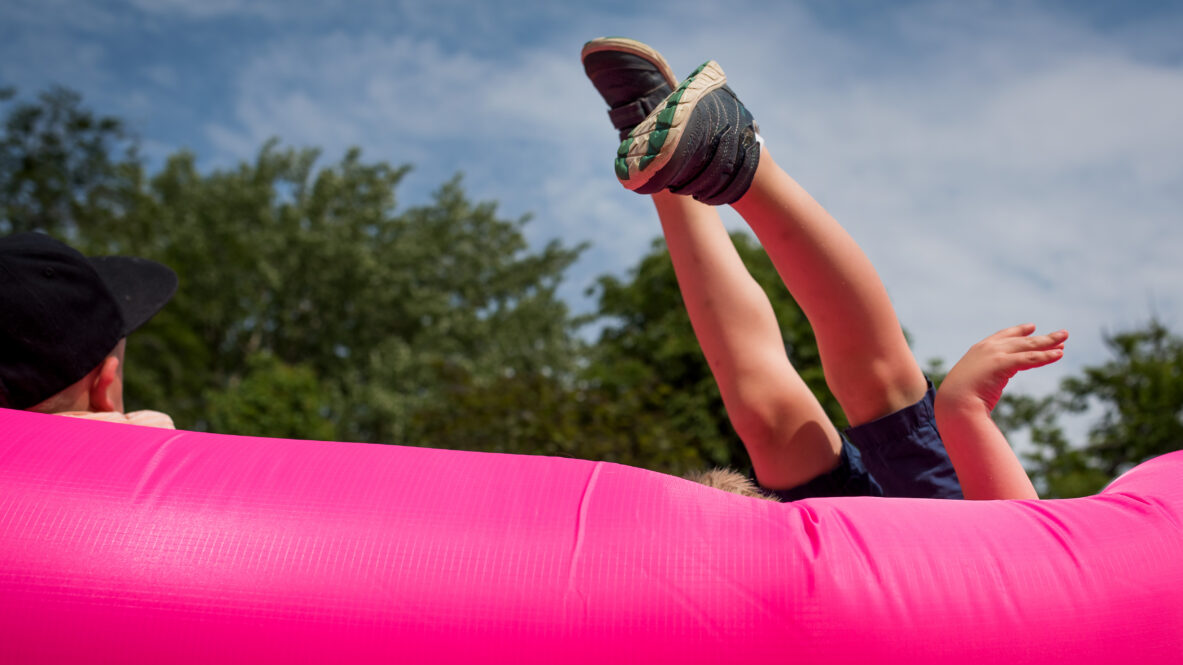 Ett barns ben och fötter sticker upp från en uppblåsbar soffa